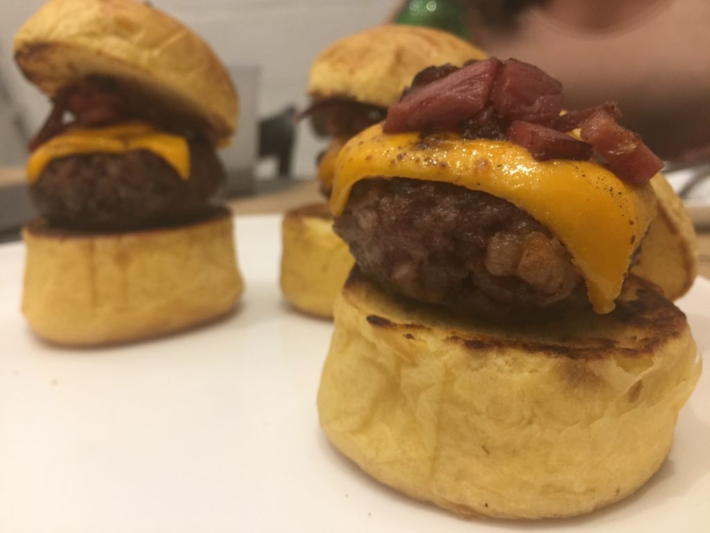 Mini Burgers (R$ 12) - 3 mini burgers com queijo cheddar e bacon.